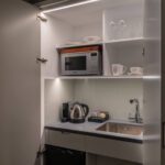 A miniature kitchen with a built in fridge and microwave, located in Covent Garden.