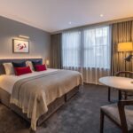 A superior room with a double bed, dining table and television, located in Covent Garden.