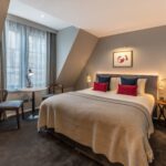 A spacious superior room with a double bed, and dining table, located in Covent Garden.