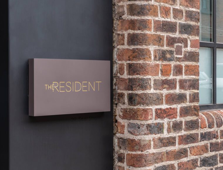 A modern sign on a dark wall reads 