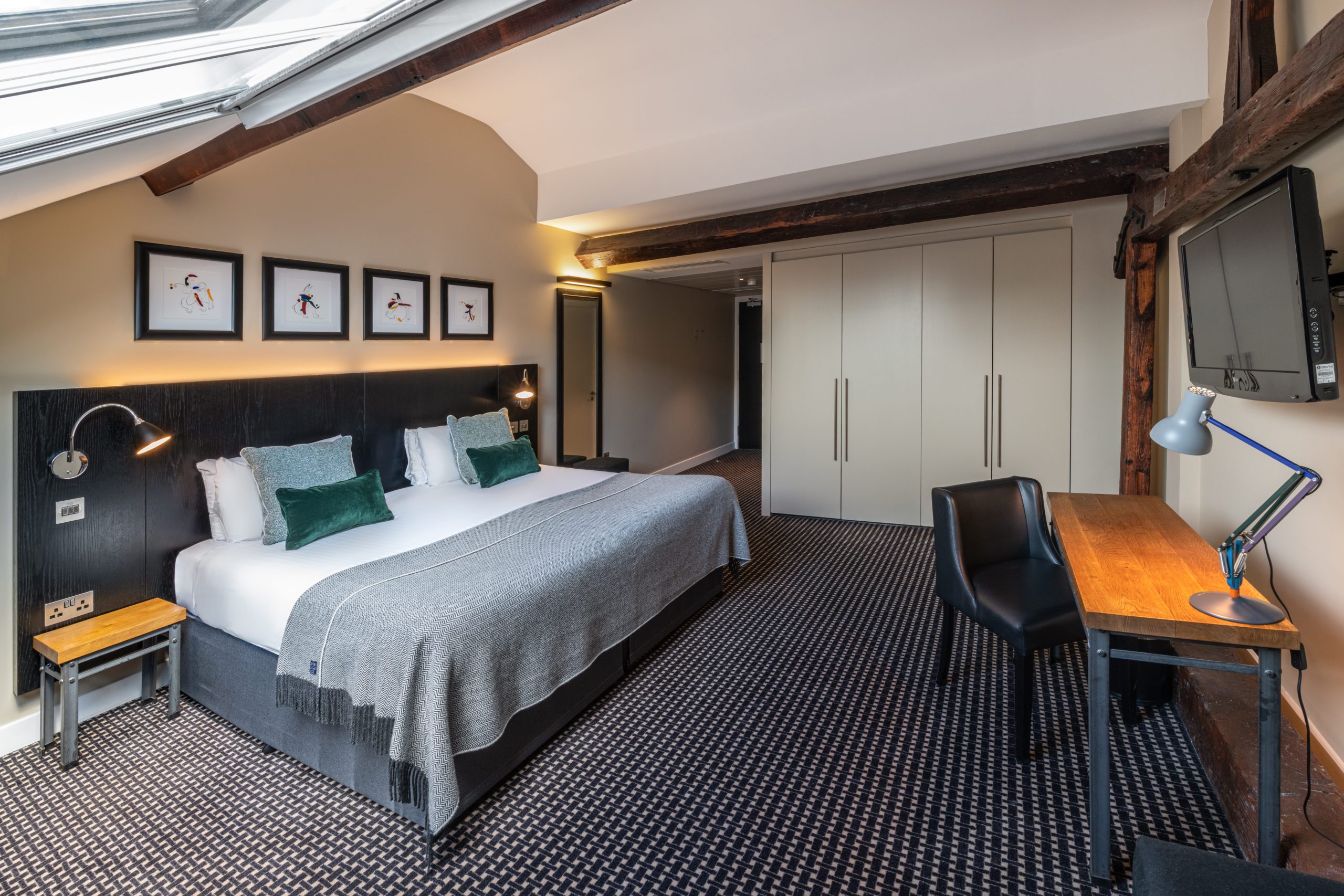 A deluxe room, with a double bed and desk, located in Liverpool.