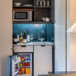 A built in miniature kitchen area with a fridge and microwave, located in Soho.