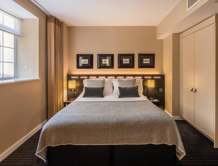 A suite with a double bed, bedside tables and built in wardrobes, located in Victoria.